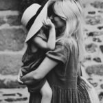 grayscale photography of woman carrying girl